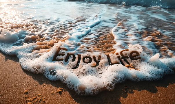 Relaxing summer vibes with Enjoy Life message handwritten in the sand, washed over by foamy sea waves under golden sunlight