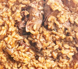 Close-up of traditional risotto with braised meat, cooked to a creamy texture in a bowl.