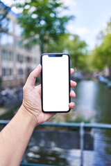 Man holding smartphone showing white blank screen at amsterdam