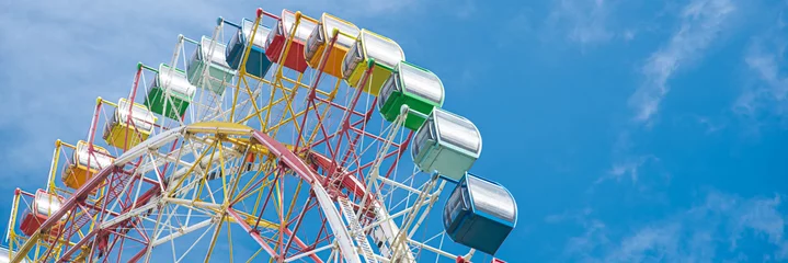 Papier peint adhésif Parc dattractions Panorama colorful sightseeing cabin or multiple passengers carrying components with support frame, rim of modern Ferris Wheel at amusement park in Nha Trang, Vietnam, blue sky, spoke cable
