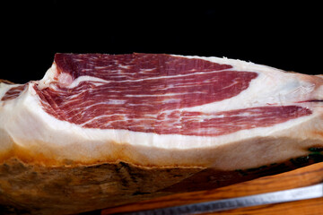 Piece of black leg Iberian ham on cutting board