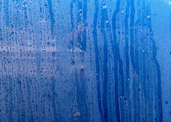 Fototapeta na wymiar Raindrops on a blue car close-up.
