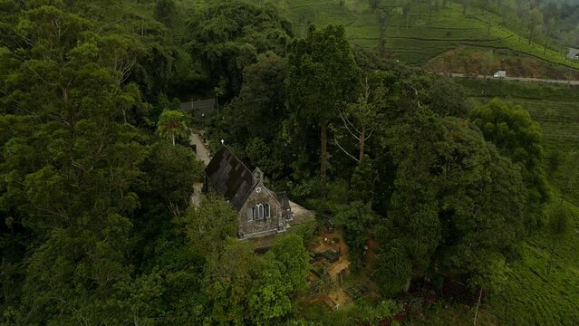 A colonial Christian Church on the hill by the lake among the patterned tea plantations. Highland nature landscape of Sri Lanka