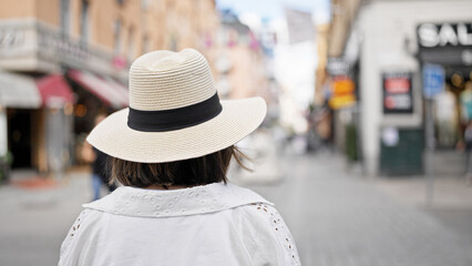 Beautiful young hispanic woman walking away in the streets of Stockholm