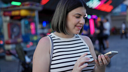 Young beautiful hispanic woman smiling happy using smartphone at Prater Vienna