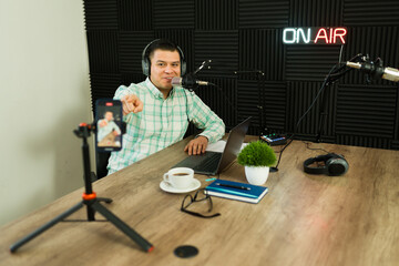 Happy radio host live streaming while recording his podcast