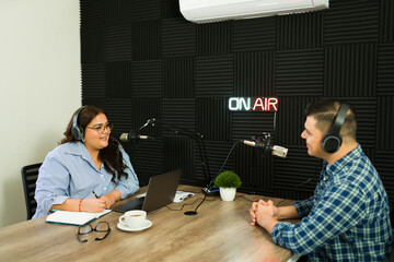 Latin woman host asking questions to a podcast guest