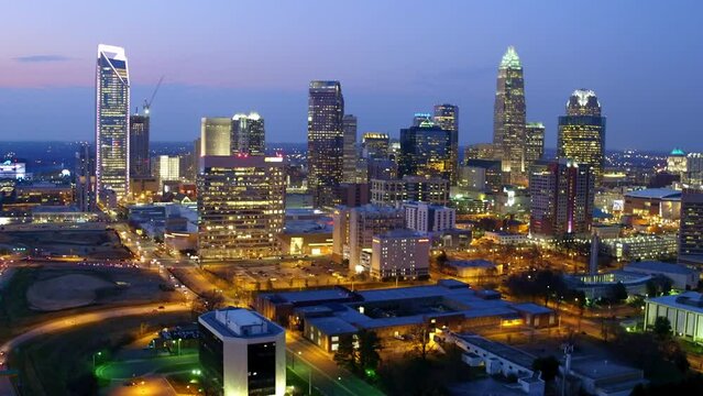 Aerial Backward Shot Of Modern Buildings In Illuminated Financial District Of City At Night - Charlotte, North Carolina