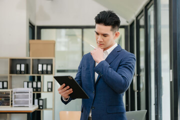 Young attractive Asian male office worker business suits smiling at camera in office