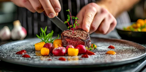 Fotobehang Chef Adding Final Touch to Fillet Steak with Vegetable Accents on a Slate Plate  © Infini Craft