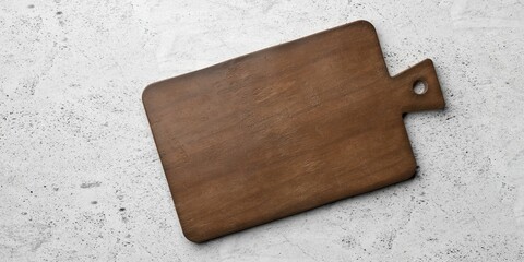 Old rustic empty wooden cutting or chopping board on concrete table background flat lay top view from above