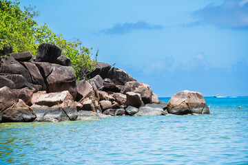 The rocky jungle coast of the Seychelles island of Praslin. - obrazy, fototapety, plakaty