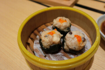 Chicken dimsum served in bamboo plate. Dimsum is a large range of small dishes that Cantonese people traditionally enjoy in restaurants for breakfast and lunch.
