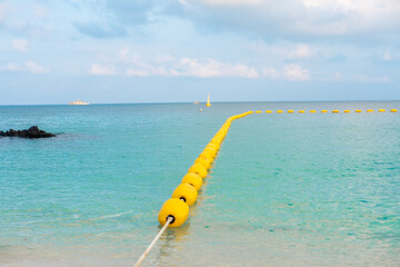 Beautiful views of the beach, sea, rocks during the day with buoys separating the swimming area.