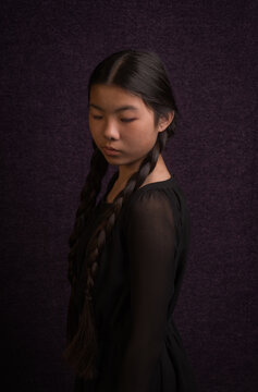 classic painterly portrait of asian girl in black dres and dark renaissance style