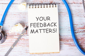 YOUR FEEDBACK MATTERS text is written on a notebook that lies on old vintage boards