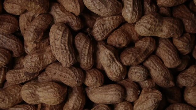Pile of peanut shells rotates clockwise. Top view of rotating peanuts. Healthy nutrition concept