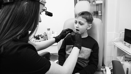 little emotional boy, fair-haired teenager, sitting in the otolaryngologist's office, waiting for the doctor for an examination, but smiling. Physical examination - obrazy, fototapety, plakaty