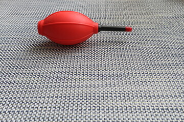 A red pear with a black tip. Pear for cleaning the camera.