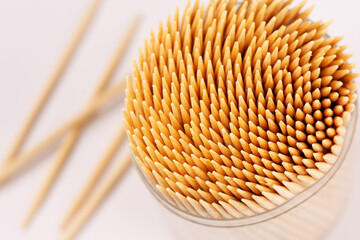 A set of bamboo toothpicks on a white background. Close-up photo. - obrazy, fototapety, plakaty