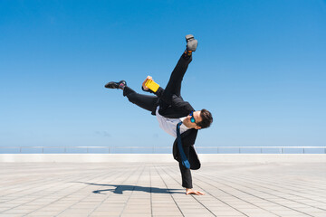 Flexible and cool businessman doing acrobatic trick - obrazy, fototapety, plakaty