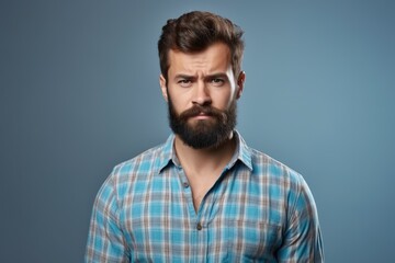 Fototapeta premium A man with a beard is captured in this photo, wearing a blue shirt.