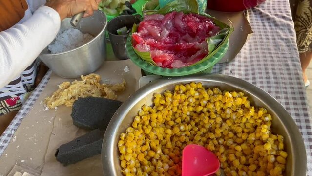 Traders of traditional Central Javanese foods such as Cenil, getuk, corn, coconut and granulated sugar serving buyers by cutting the food and wrapping it in banana leaf containers.