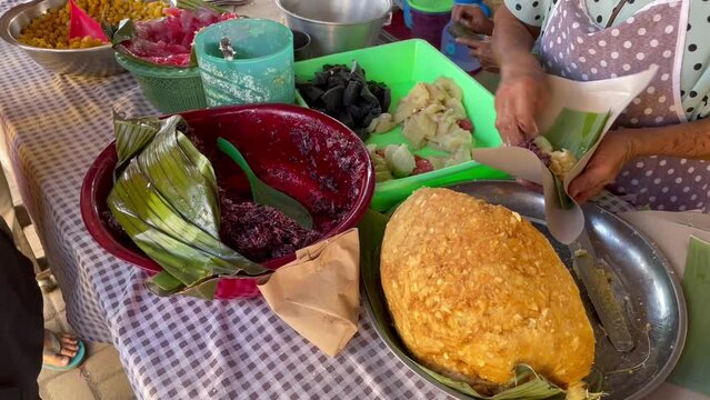 Traders of traditional Central Javanese foods such as Cenil, getuk, corn, coconut and granulated sugar serving buyers by cutting the food and wrapping it in banana leaf containers.