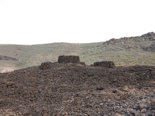 Native guanche burial mound in volcanic rock at archeological dig in Agaete, Gran Canaria, Spain