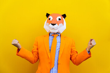 Cool man wearing colorful stylish suit with 3d origami animal funny mask on isolated colored...