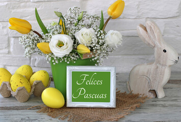 Felices Pascuas: Decoración de Pascua con un ramo de flores, huevos de Pascua y un conejito de...