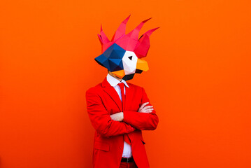 Cool man wearing colorful stylish suit with 3d origami animal funny mask on isolated colored background