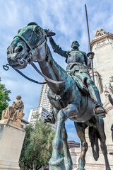Fototapeta premium Don Quijote de la Mancha, with his horse Rocinante, the famous statue at Plaza de Espana of Madrid, Spain. It is the literary personage created by author Miguel de Cervantes and a symbol of Madrid. 