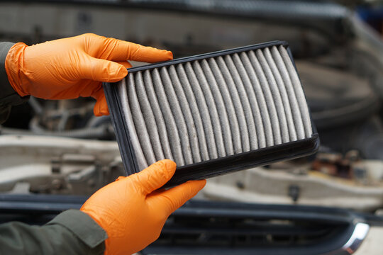Closeup mechanic's hands hold air filter pad of car engine to check. Concept, car broken,repair and maintenace service. Dirty air fillter need to change for hygienic.  