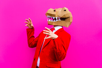 Cool man wearing colorful stylish suit with 3d origami animal funny mask on isolated colored background
