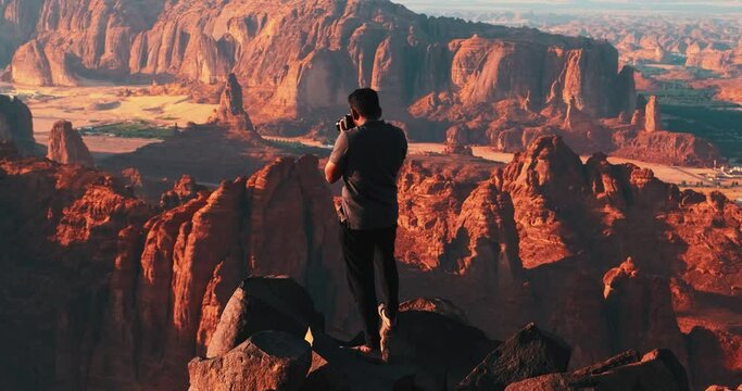 Man on the edge of a cliff during sunset