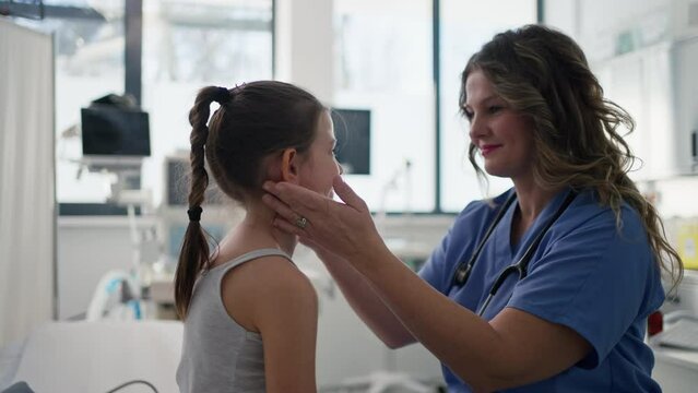 Doctor examining lymp nodes on neck of the young girl. Palpation of lymph nodes. Concept of preventive health care for children.