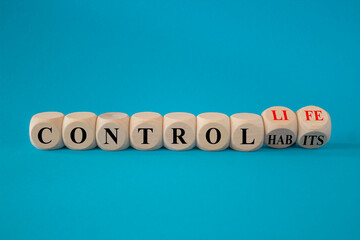 Concept red words Control habits to Control life on beautiful wooden cubes. Beautiful blue background, copy space. Business control habits and life concept.