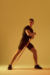 Athletic man with fit muscular body training in studio