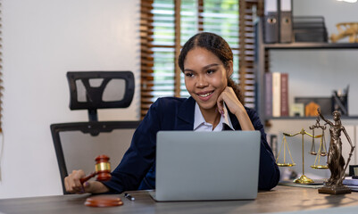 Portrait of young female Lawyer or attorney working in the office, analyzing data, reading contract documents work with law books hammer of justice Consulting lawyer concept.