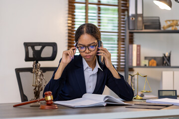 Portrait of young female Lawyer or attorney working in the office, analyzing data, reading contract documents work with law books hammer of justice Consulting lawyer concept.