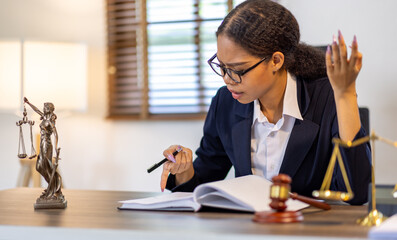 Portrait of young female Lawyer or attorney working in the office, analyzing data, reading contract documents work with law books hammer of justice Consulting lawyer concept. - obrazy, fototapety, plakaty