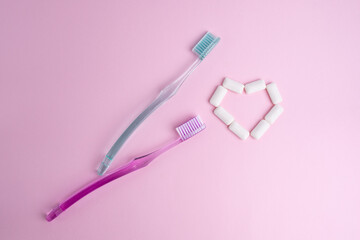 Toothbrush and chewing gum lie on a colored background. Time to brush your teeth. Top view, flat lay. Dental health concept
