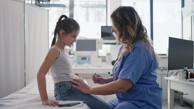 Nurse injecting insulin in diabetic girl belly. Close up of young girl with type 1 diabetes taking insuling with syringe needle.