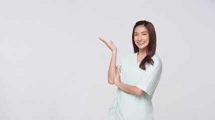 Young Asian woman wearing patient outfits presenting or showing open hand palm with copy space for product isolated on white background. dvertisement life insurance