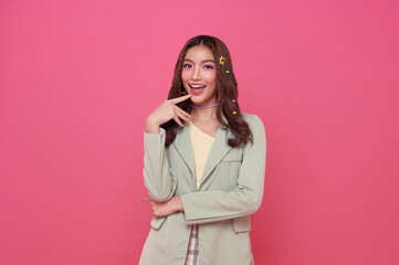 Young happy asian teen woman thinking something isolated on pink background.