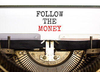 Follow the money symbol. Concept words Follow the money typed on beautiful old retro typewriter. Beautiful white paper background. Business and follow the money concept. Copy space.