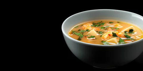 Fotobehang Tom Yum Goong Soup with Fresh Shrimp. Thai Tom Yum soup garnished with cilantro in a bowl, copy space. © IndigoElf