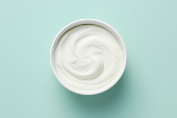Top view of bowl with white quark or cream on mint green background - obrazy, fototapety, plakaty