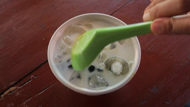 Dawet ice (Indonesian traditional beverage) is being stirred to drink on a hot day